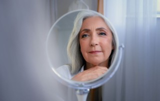 Mirror reflection female wrinkled face 50s middle-aged Caucasian woman senior lady looking self