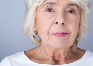 A woman with white hair and pink lipstick.