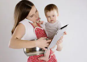 A woman holding a baby and an ipad