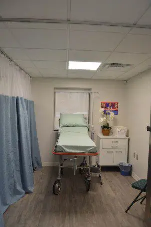 A hospital room with a bed and curtains