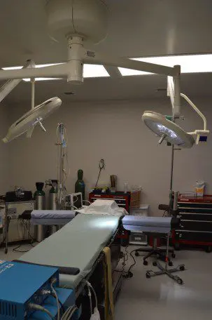 A room with two surgical lights and a table