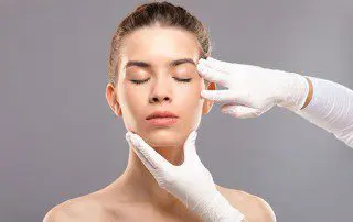 A woman getting her face waxed by an esthetician.